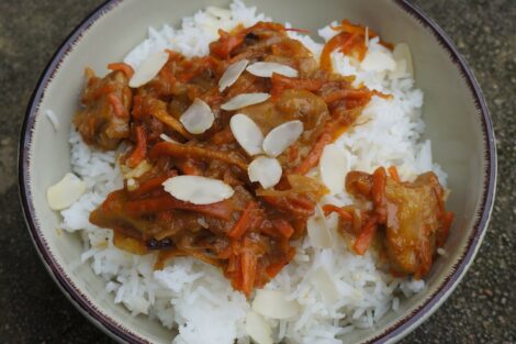 Bowl of Orange Stew with rice and almonds