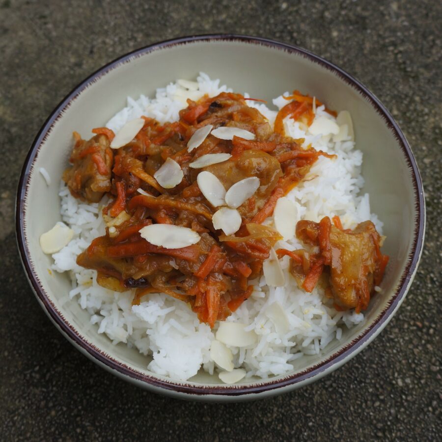 Bowl of Orange Stew with rice and almonds